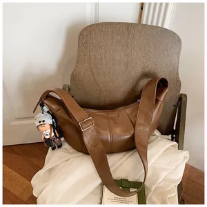 Gedetailleerd overzicht van de bruine vintage slouchy schoudertas met brede riem en leuke hanger.