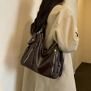 Detailed view of women large brown shoulder tote bag with zippers and stylish mini pouch charm.