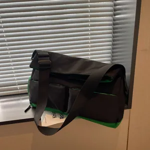 Vista dettagliata della borsa a tracolla nera e verde con tasche multiple e cinghia regolabile.
