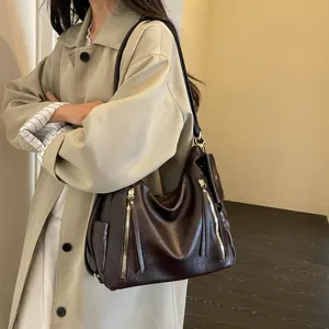 Stylish dark brown leather shoulder bag featuring dual zipper design for daily commute.