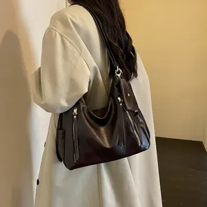 Detail shot of a stylish dark brown hobo shoulder bag for women, featuring zipper design.