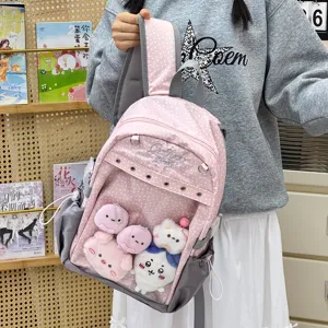 Dettaglio zaino scolastico rosa a pois, tasca anteriore trasparente con simpatici peluche.