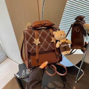 Zaino mini vintage marrone da donna con motivo a rombi, decorazione a stella e grazioso ciondolo.