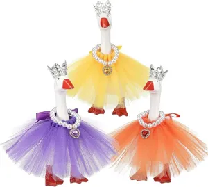 Primo piano sui dettagli di figurine di oche decorative con corone e gonne di tulle colorate.