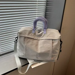 Grande borsa da viaggio con eleganti manici viola e dettagli con tracolla regolabile.