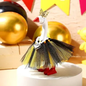 Primo piano della statuetta d'oca decorativa con corona e gonna in tulle nero giallo.