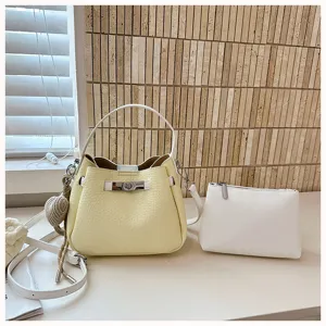 Sac seau jaune chic avec pochette assortie, sac à bandoulière en cuir texturé élégant.