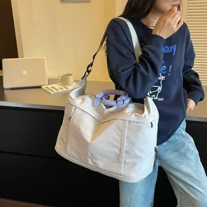Vista dettagliata della grande borsa da viaggio con manici eleganti e tracolla.