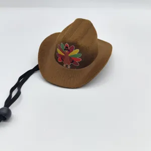 Close-up detail of the brown felt pet cowboy hat featuring a colorful Thanksgiving turkey pattern.