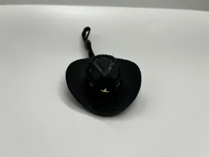 Close-up detail of a miniature black cowboy hat with strap, ideal for doll or toy decoration.