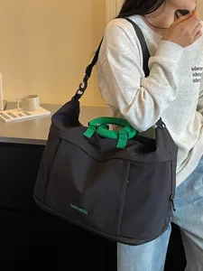Grande borsa da viaggio nera con manici verdi, elegante borsa a tracolla leggera.