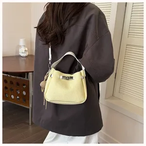 Vue détaillée du sac-seau minimaliste en cuir jaune pour femme avec poignée et sangle.