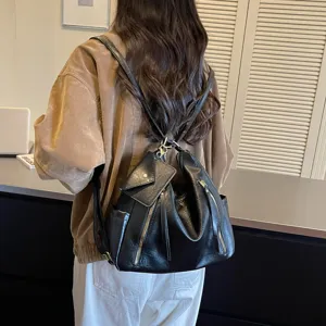 Stylish black leather hobo backpack with zipper pockets and small coin purse accessory.