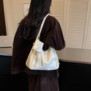 Detail view showing the white shoulder bag with zipper pockets and attached small pouch.