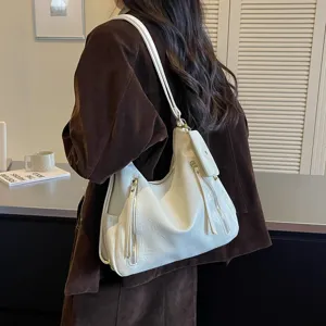 Detailed view of the stylish white slouchy shoulder bag with zipper and comfortable strap.