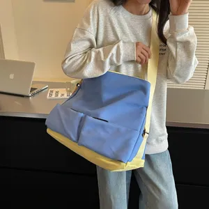 Dettaglio borsa a tracolla in tela blocco di colore blu giallo, grande capacita tasche.