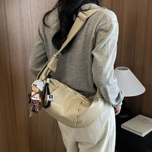 Gedetailleerd overzicht van de stijlvolle slouchy hobo tas met schattige pop sleutelhanger.