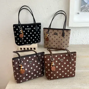 Classic polka dot tote bag with charming pendant, elegant commuter shoulder handbag.