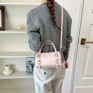 Borsa a tracolla cilindrica rosa da donna con doppi manici per look quotidiani.