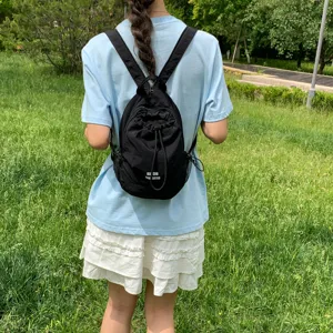 Pequeña mochila negra para mujer, ligera y casual con cordón para uso diario al aire libre.