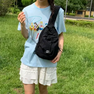 Vista detallada de la mochila negra para exteriores con cordón y bolsillo de red en el parque.