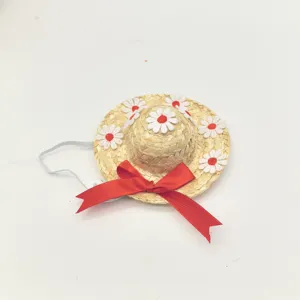 Detailed close-up of pet straw hat featuring cute daisy appliques and red ribbon bow.