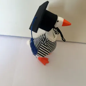Desktop graduation duck figurine with black cap and striped shirt, cute tabletop decor.