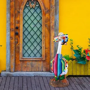 Vista detallada de la estatua de jardin de ganso estilo mexicano con sombrero y poncho colorido.