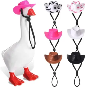 Statuetta di anatra con un set di sei mini cappelli da cowboy in plastica per decorazione.