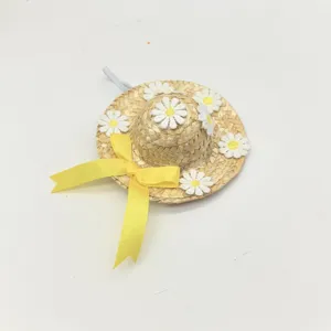 Detailed view of the pet straw hat featuring white daisy appliques and a yellow ribbon.