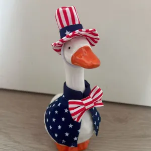 Patriotic ceramic goose figurine with American flag top hat and vest for 4th of July desktop decor.