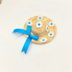 Cute small straw hat for pets with blue ribbon and white daisy flowers, summer accessory.