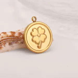 Stainless steel gold round four leaf clover pendant detail view with natural seashell prop.