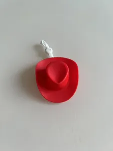 Mini cappello da cowboy rosso in plastica con cordino elastico per decorazioni.