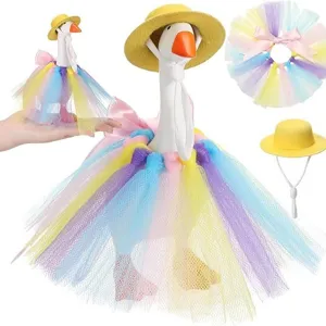 Desktop little white duck figurine set with yellow straw hat and colorful tutu skirt for decor.