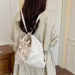 Vista detallada de la mochila y bolso de hombro coreano casual con lindo colgante de oso.