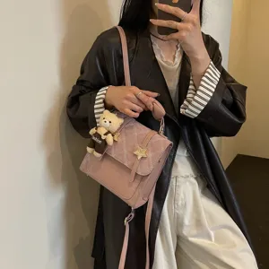 Dettaglio zaino donna rosa, elegante borsa a tracolla da lavoro con grazioso ciondolo.