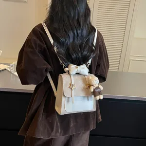 Vista dettagliata di zainetto mini da donna carino con decorazione a fiocco e ciondolo orsetto.