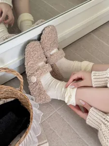 Close-up detail of cozy fluffy fuzzy shoes and cute lace pearl ruffle socks for autumn.