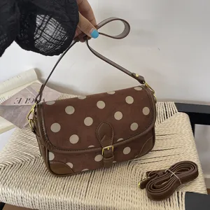 Gedetailleerd overzicht van de retro bruine schoudertas met stippen en klepsluiting.