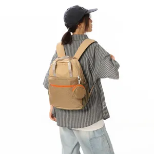 Vue arrière d'une femme portant un sac à dos de voyage en nylon kaki pour le trajet quotidien.