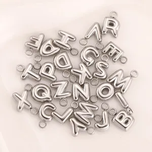 Detail van roestvrijstalen opgeblazen letter bedels, minimalistische DIY sieraden accessoires.
