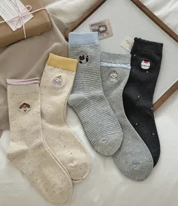 Close-up detail of cute cartoon animal embroidered crew socks with soft speckle yarn.