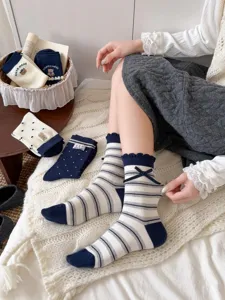 Detailed view of cute Japanese navy blue striped mid-calf socks with bow and bear design.