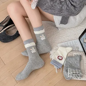 Close-up detail of grey women socks featuring cute bear embroidery and lace trim.