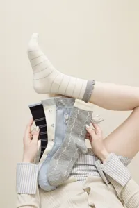Primer plano detallado de calcetines hasta media pantorrilla estilo JK con bordados.