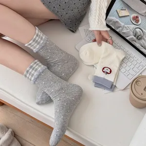Detailed view of grey polka dot and plaid cuffed women vintage socks with sweet lace trim.