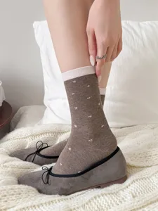Primer plano detallado de calcetines marrones con bonitas flores y fondo de cama muy suave.