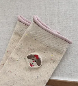 Close-up of women's autumn winter speckle yarn mid-tube socks with cute puppy embroidery detail.