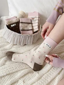 Calcetines rosas de tubo medio con diseño floral etiqueta de tela y lindo estilo.